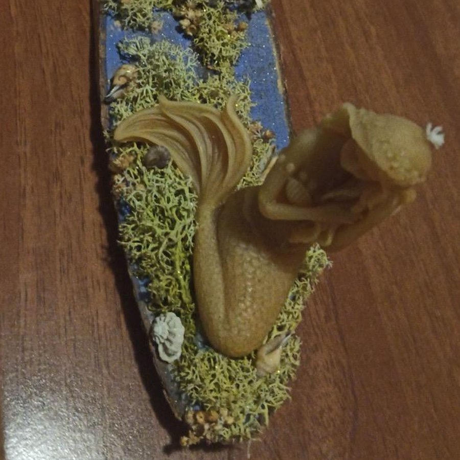 Scultura in cera d'api a forma di sirena su base di legno