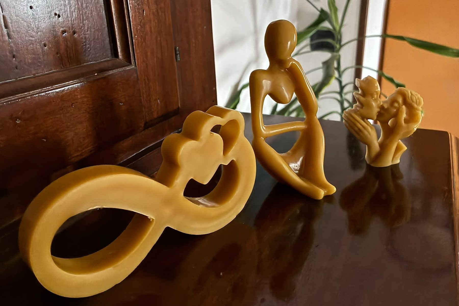 Candele scultura in cera d'api: l'infinito con due cuori, una figura seduta e l'angelo
