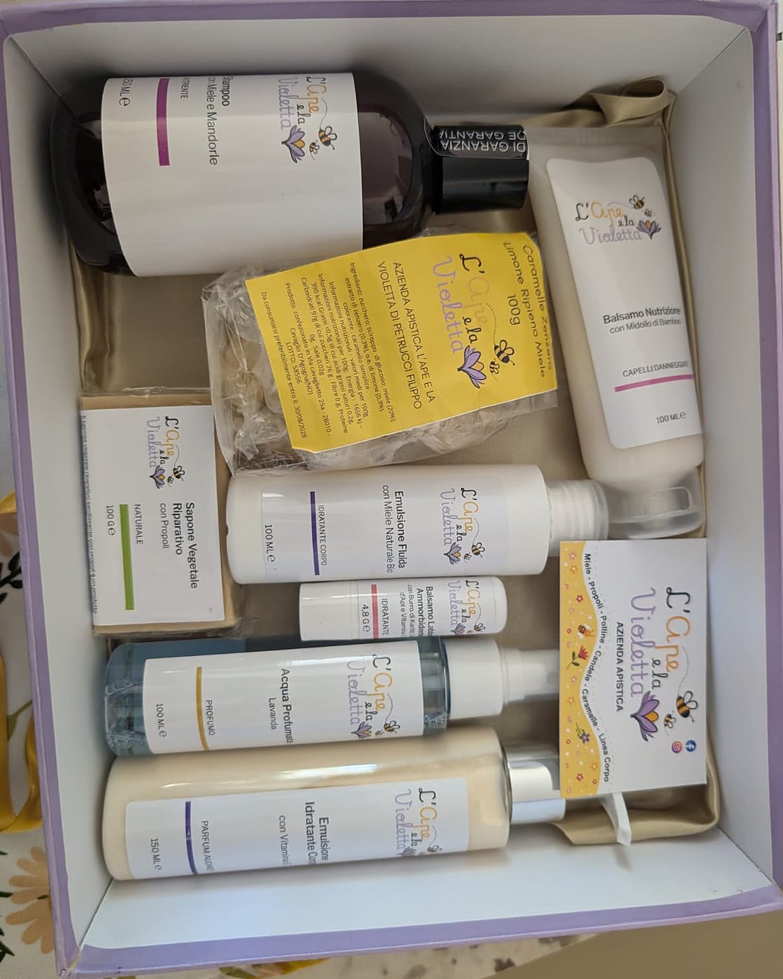 Cofanetto aperto con la linea corpo: shampoo, balsamo, emulsioni e sapone alla propoli