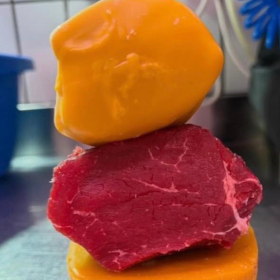 Il macellaio che avvolge un pezzo di carne nella cera d'api