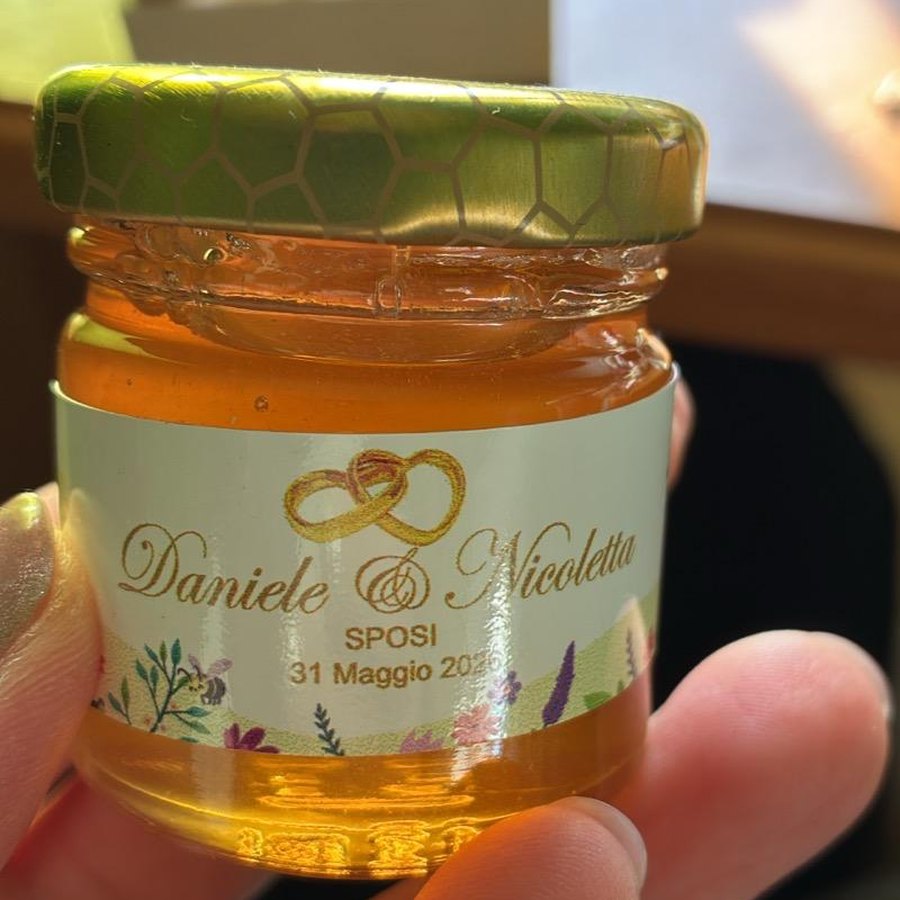 Vasetto di miele con capsula dorata a nido d'ape ed etichetta da matrimonio