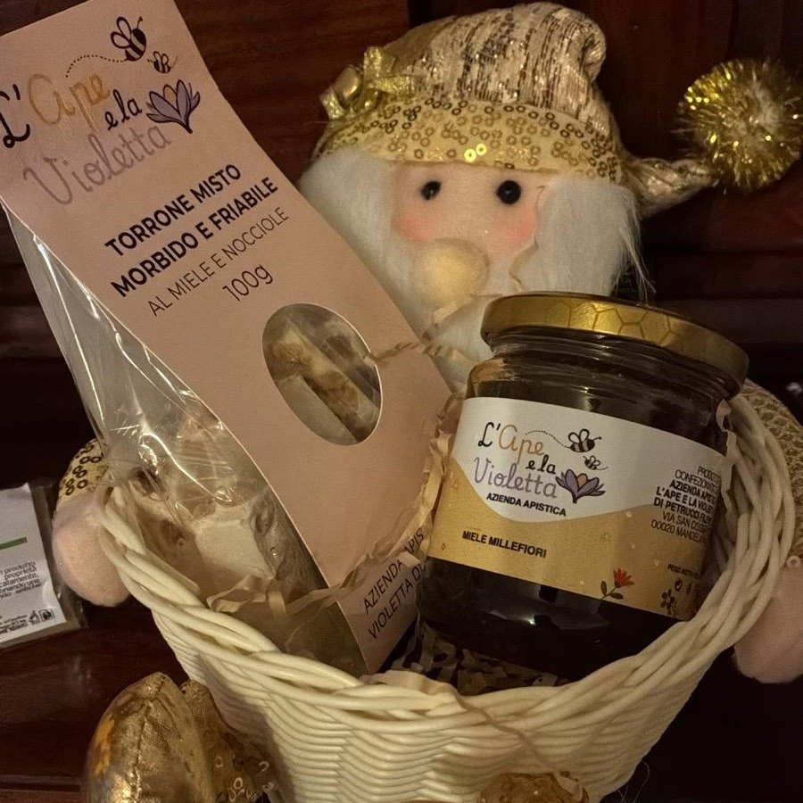 Pupazzo di Babbo Natale in stoffa bianca e oro con un vasetto di miele in grembo
