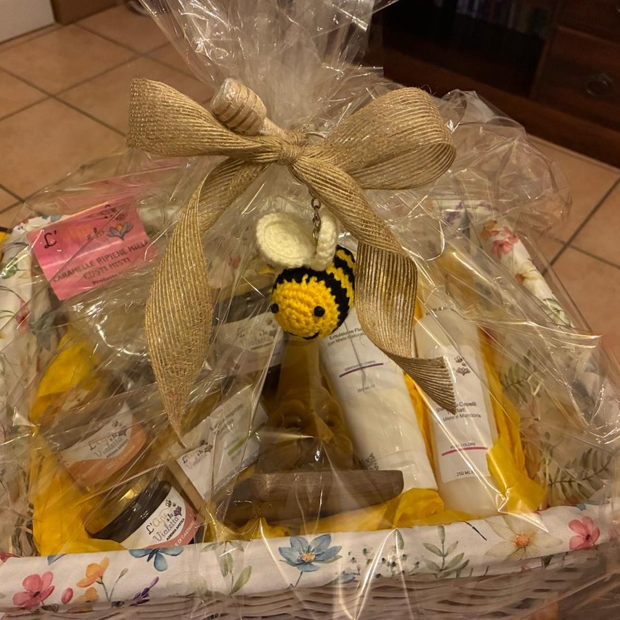 Cesto in vimini bianco foderato di stoffa a fiori, chiuso in cellophane