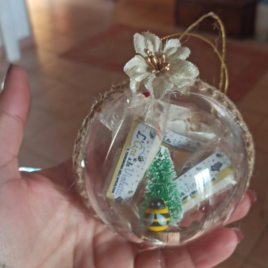 Pallina di Natale con bordo in juta e fiore dorato, con dentro un vasetto di miele
